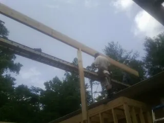 Carpenter setting a ridge beam over a new addition frame — Ice Dam Removal by Roofing Brothers in Norristown