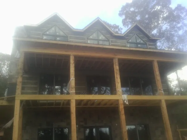 Dormers and porch framing on a large log home under construction — Roof Coating work by our crew in Norristown