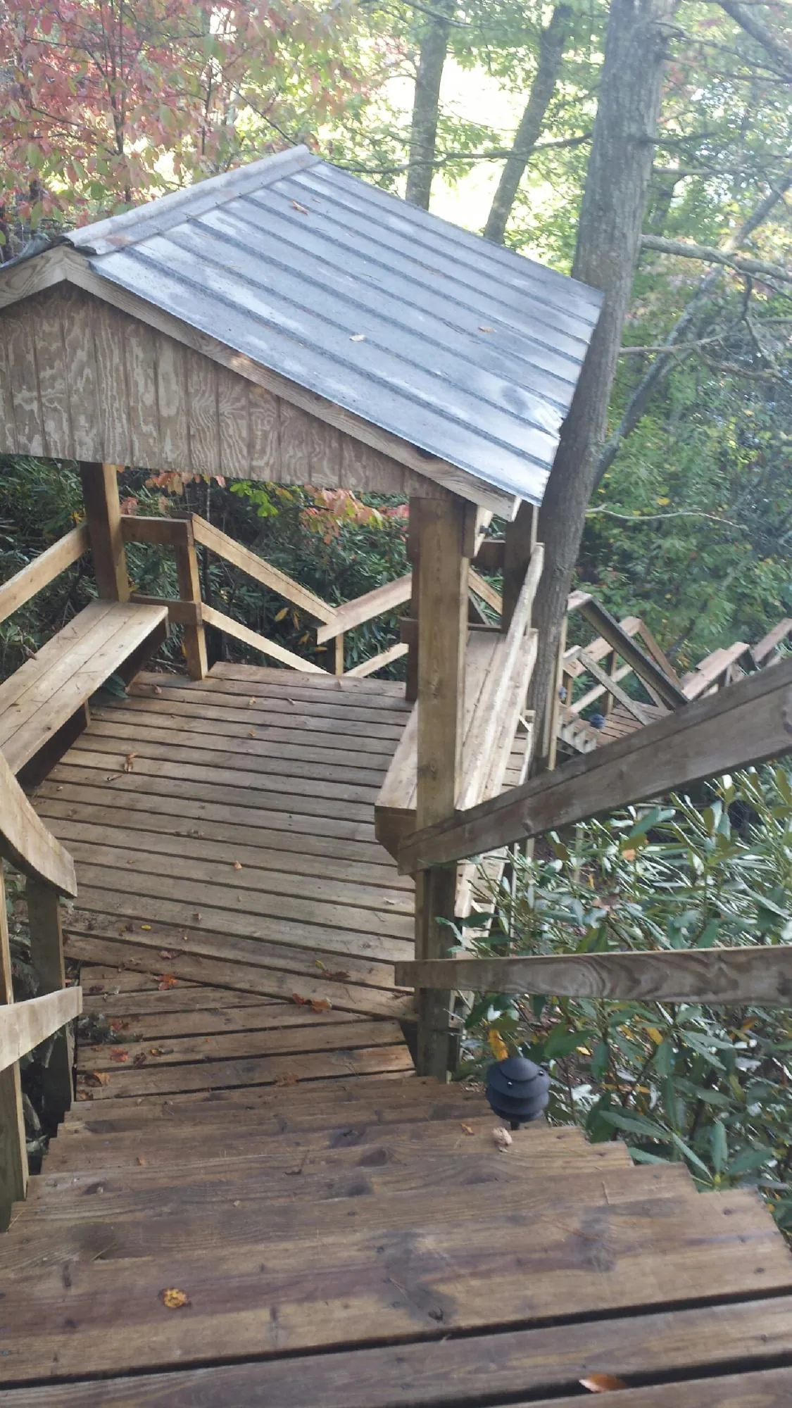 Metal roofed shelter over wooden steps on a wooded walkway — Skylight Repair & Installation work by our crew in Norristown
